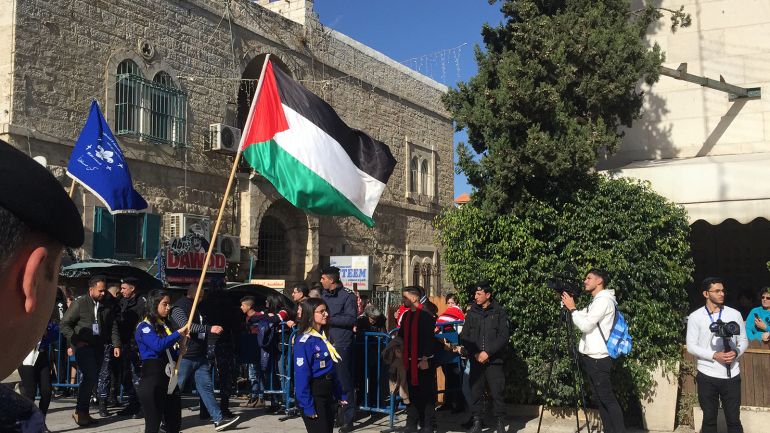 فرق كشفية تمر وسط الفلسطينيين والسياح وسط كنيسة المهد ببيت لحم في عيد الميلاد المجيد للطوائف المسيحية التي تسير حسب التقوييم الغربي